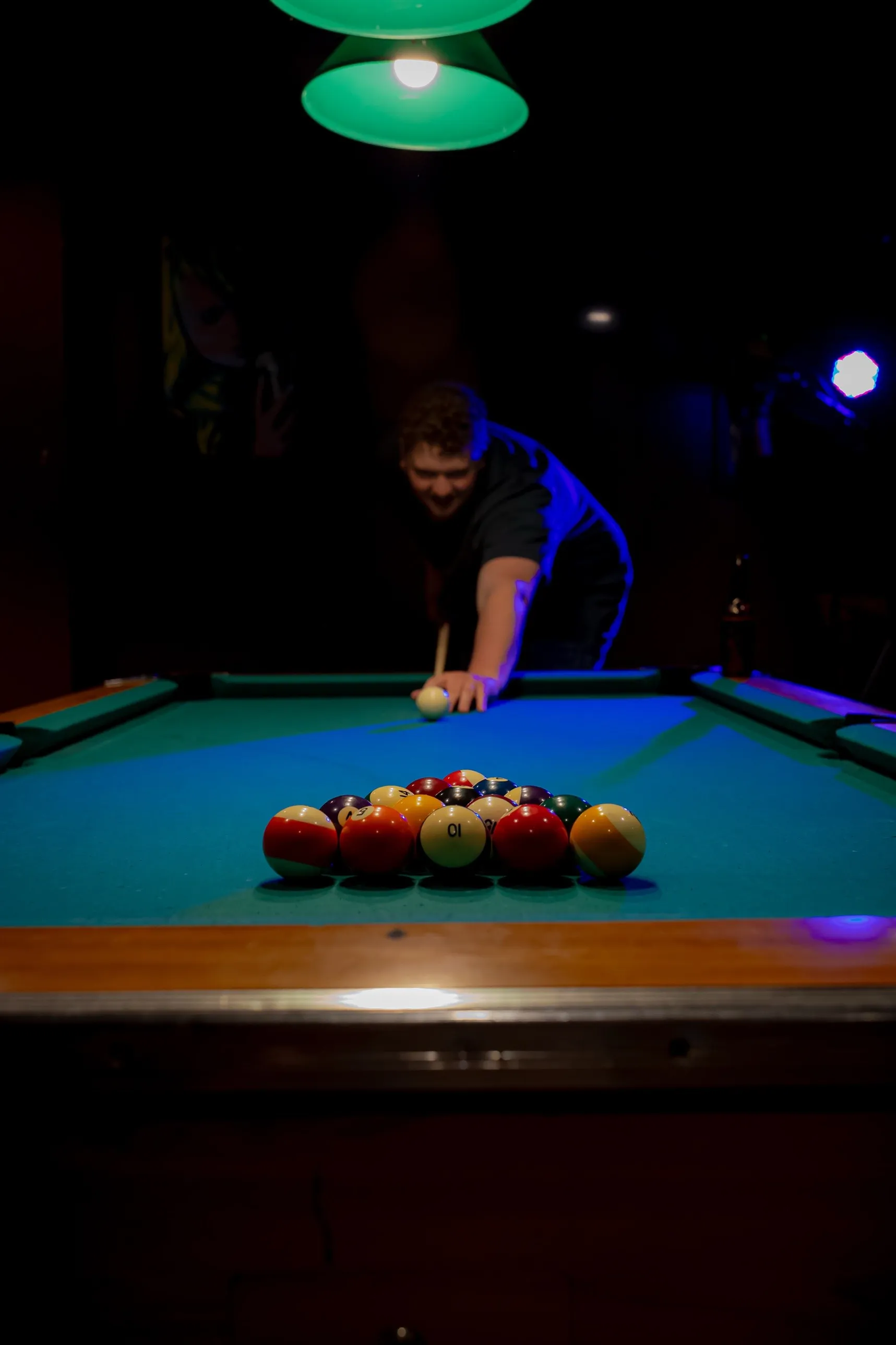 Isaac Buschur lining up a break shot at a pool table